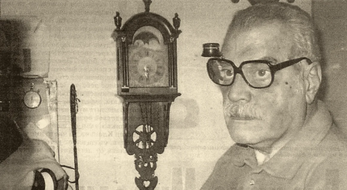 Garo Shadian with a watchmaker’s loupe, next to an antique wall clock
